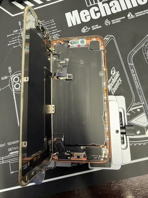 iPhone ouvert sur le tapis de travail pendant une réparation