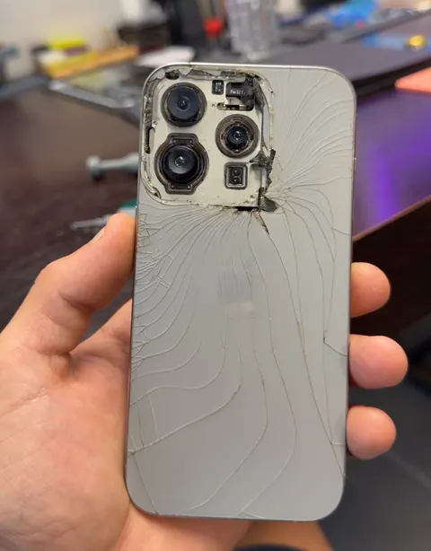 iPhone dont la vitre arrière et le cache caméra sont arrachés