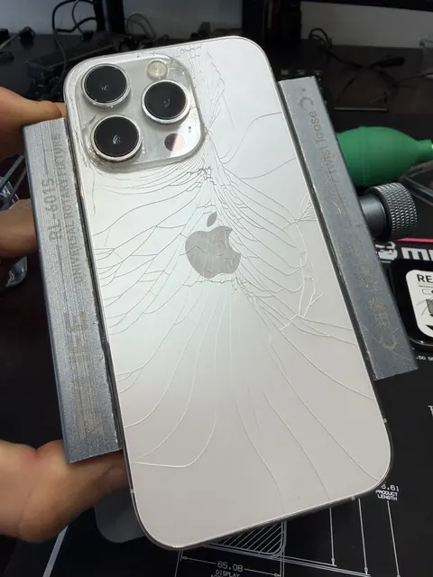 iPhone Pro blanc à la vitre arrière fissurée, sur son support